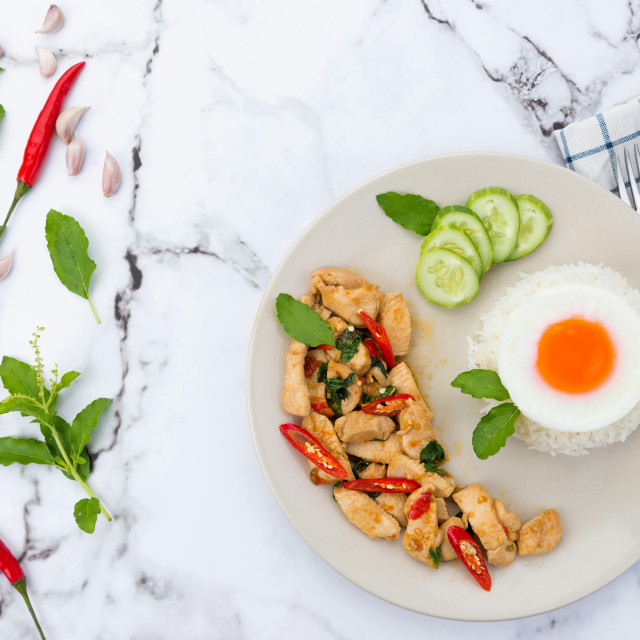 Pollo especiado servido con arroz y huevo frito